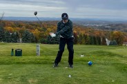 a man swinging a golf club on a golf course