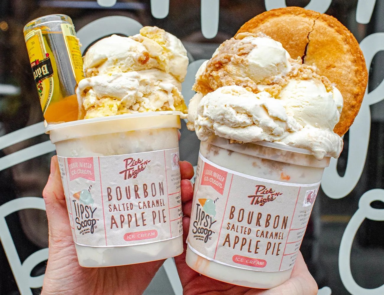 two people holding ice cream with pies in it