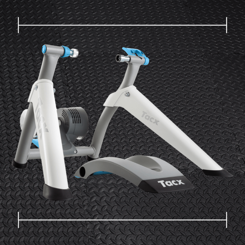 a white garmin tacx bike trainer with blue accents laid over a photo of black rubber gym flooring