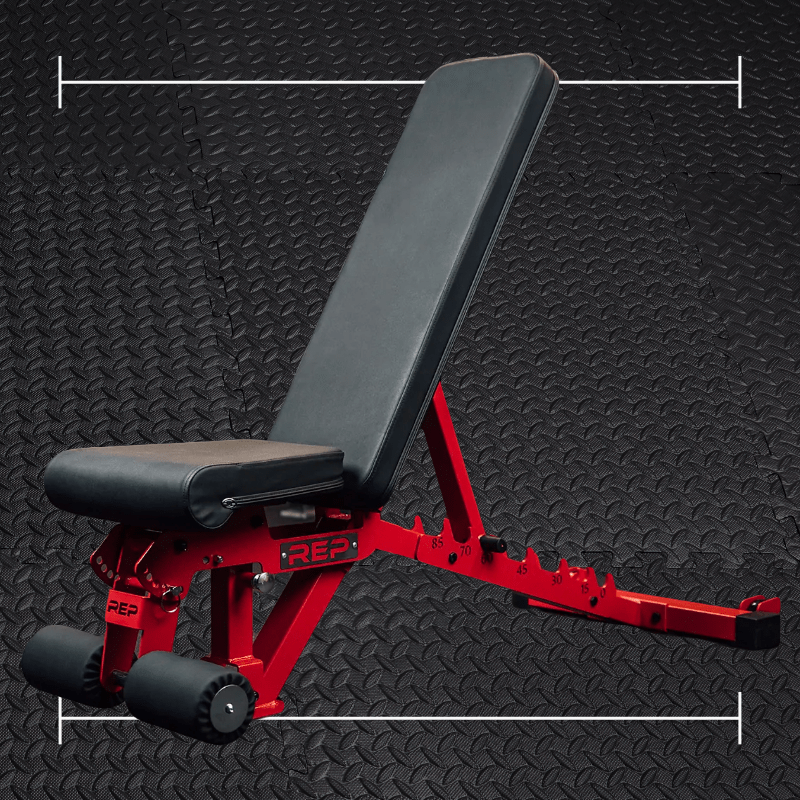 a black and red weightlifting bench laid over top a black rubber gym flooring