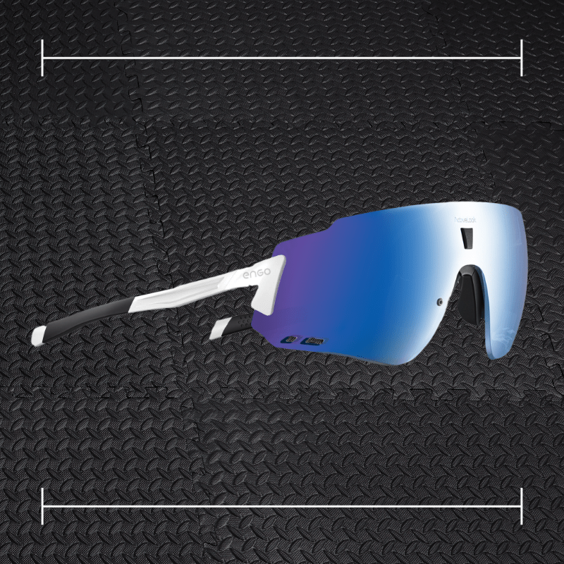 white engo sunglasses with blue and purple lenses laid on top a photo of black rubber gym flooring
