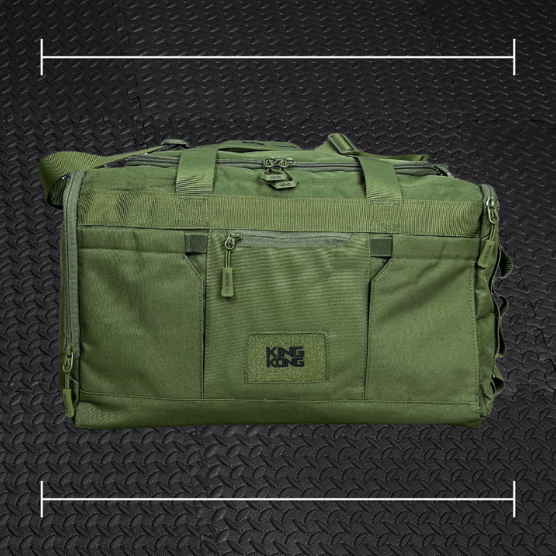 a green king kong duffle laid on top a photo of black rubber gym flooring