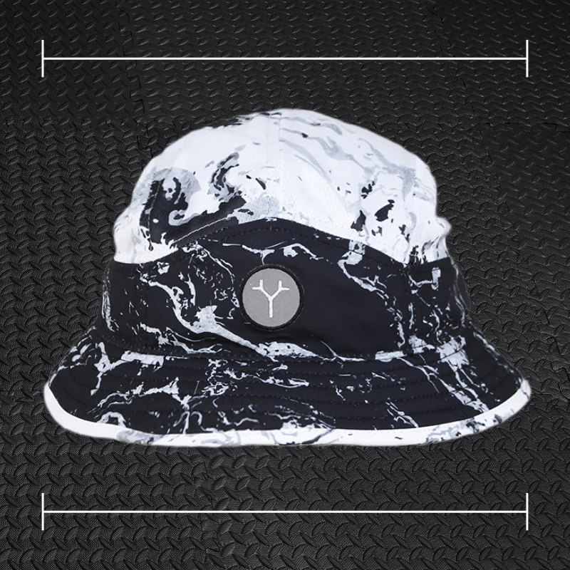 a black and white marbled bucket hat laid on top a photo of black rubber gym flooring