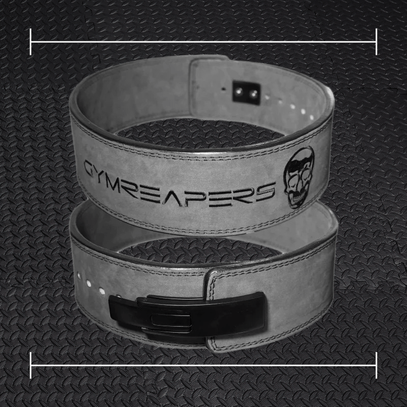 a black gym reapers belt laid over top a photo of black rubber gym flooring