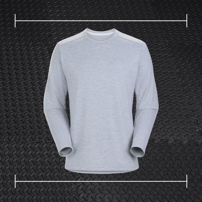 a grey acrteryx long sleeve shirt laid over top a photo of black rubber gym flooring