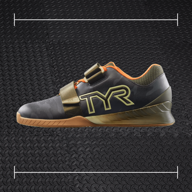 a black tyr shoe with a gum sole laid over top a photo of black rubber gym flooring