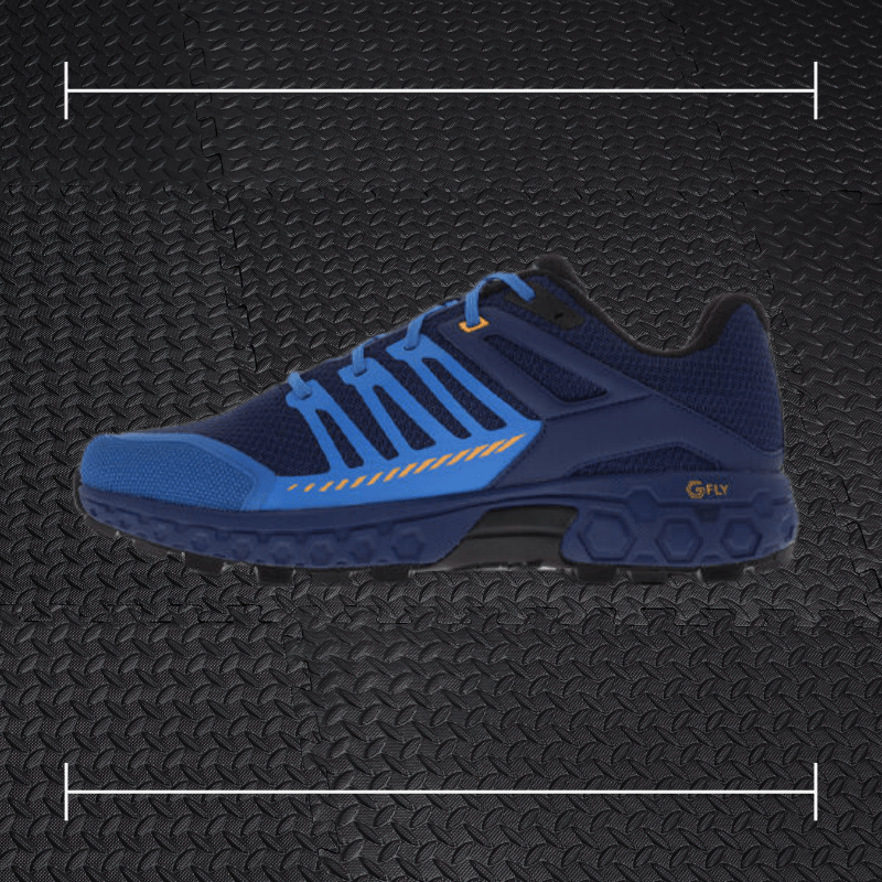 a blue and black innov shoe laid over top a photo of black rubber gym flooring