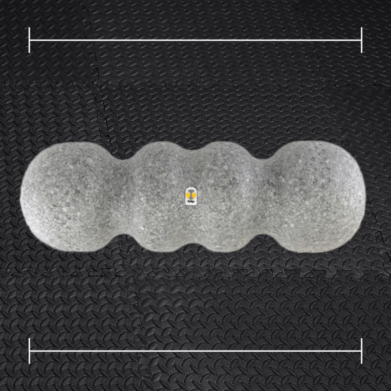 a grey foam roller laid over top a photo of black rubber gym flooring