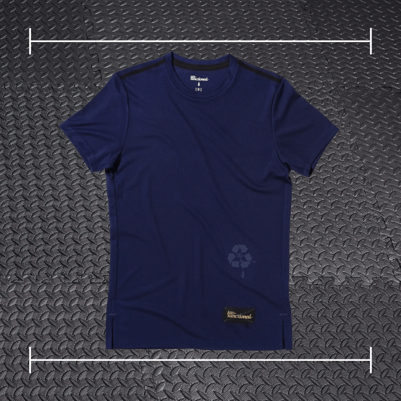 a blue purple short sleeve shirt laid over top a photo of black rubber gym flooring