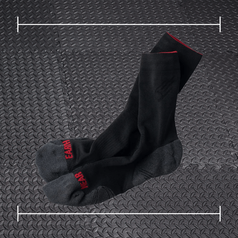 black Near Earth socks laid over top a photo of black rubber gym flooring
