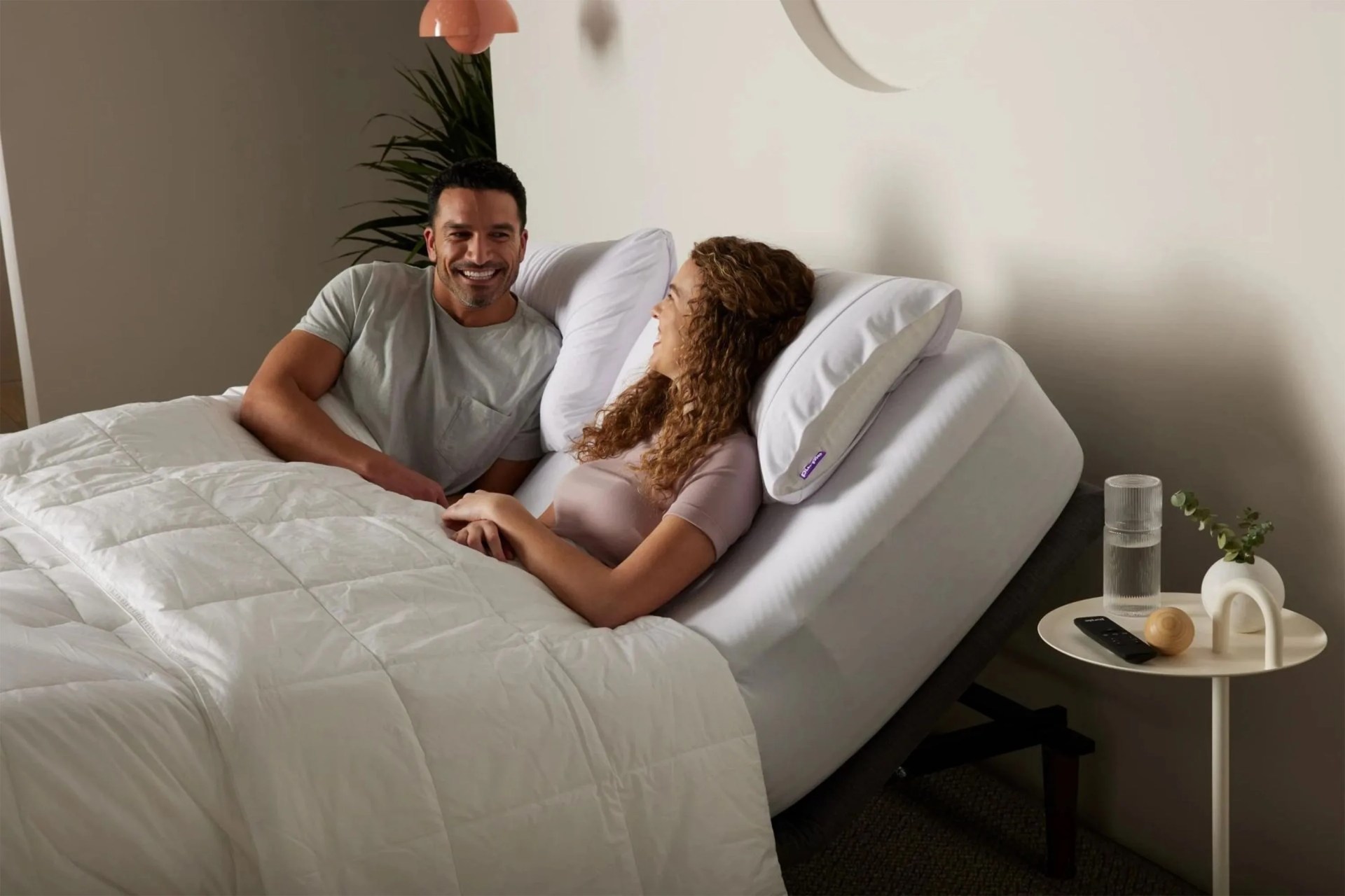 a couple laying on an adjustable bed