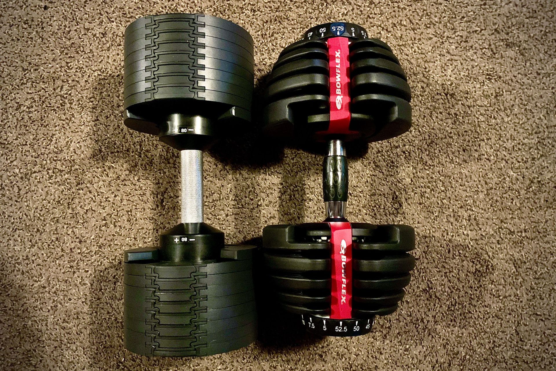nÜobell 80lb classic dumbell next to a bowflex selecttech 552 adjustable dumbbell