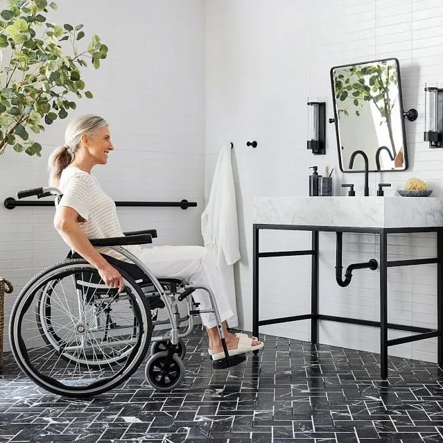 a woman in a wheelchair going up to a vanity