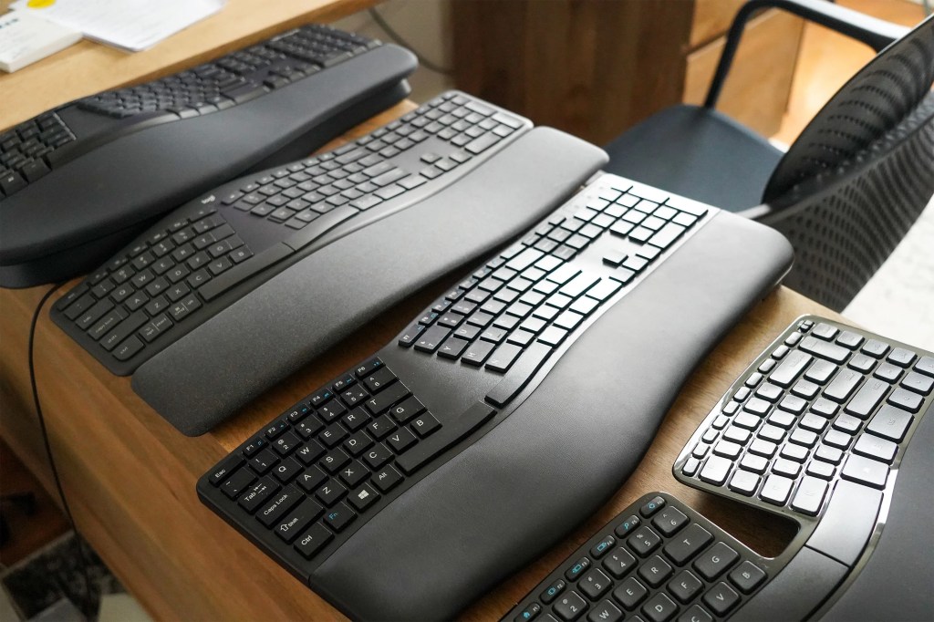 four ergonomic keyboards on a table