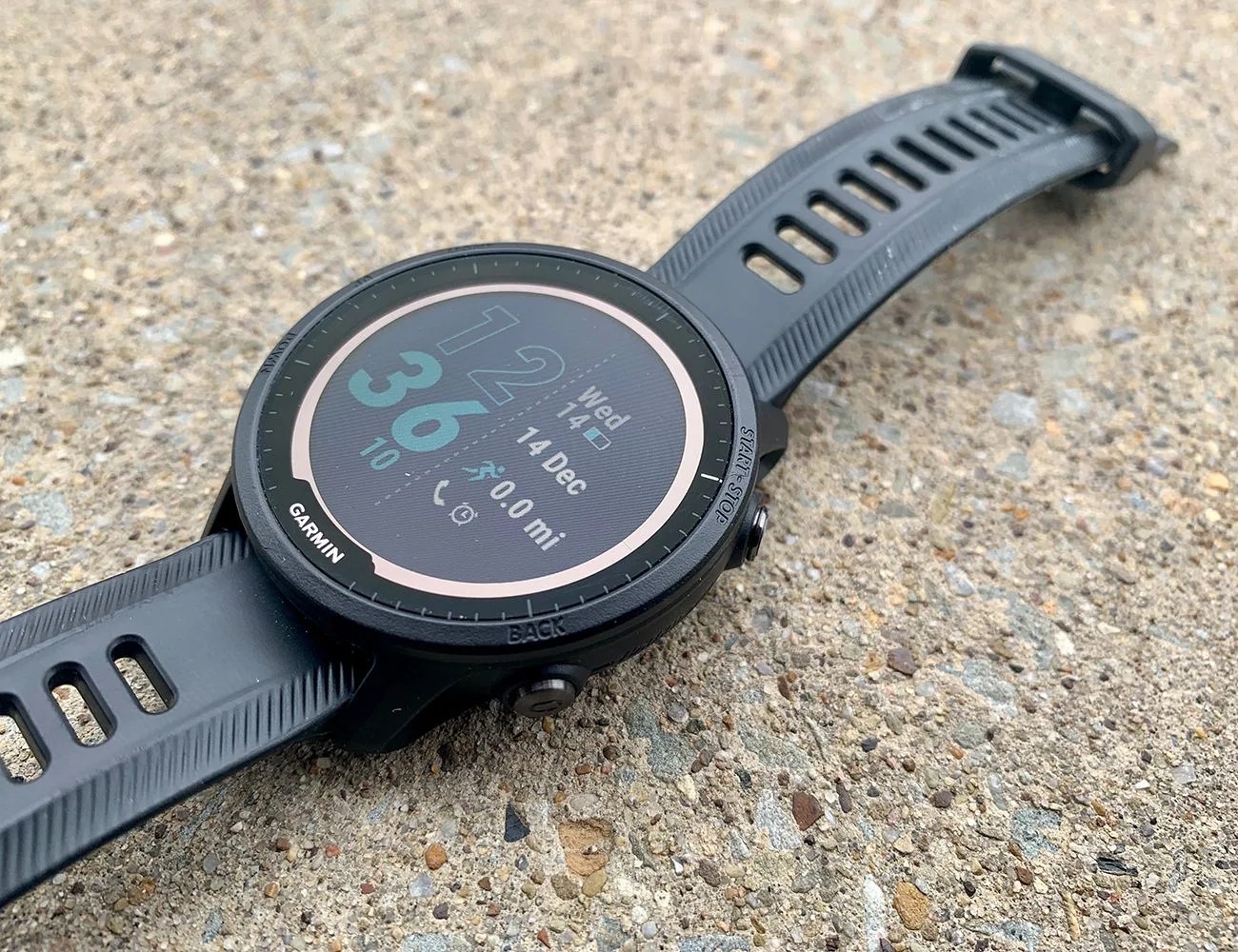 a black garmin forerunner 955 solar laying on pavement