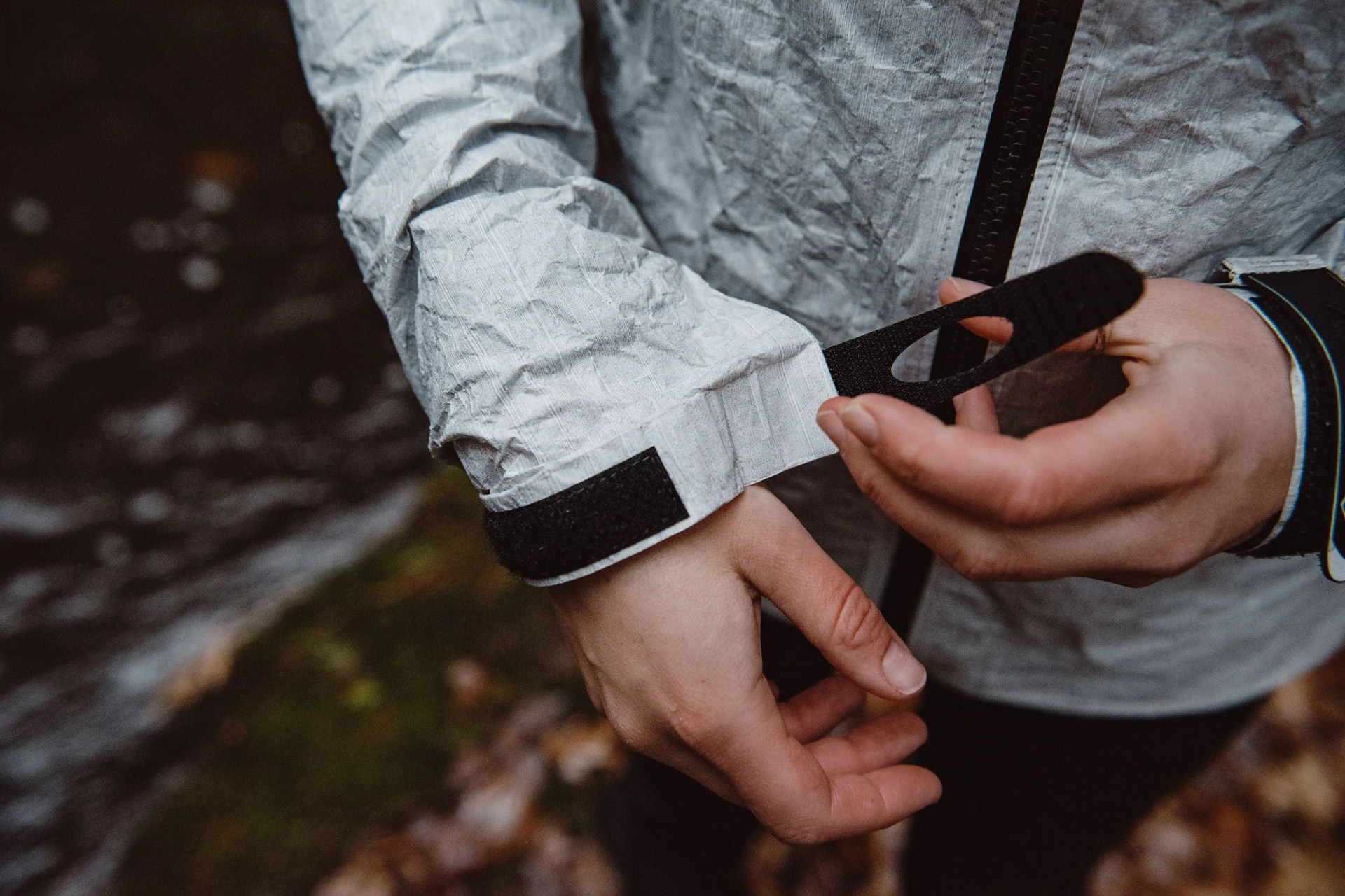 someone tightening the velcro strap on a raincoat sleeve