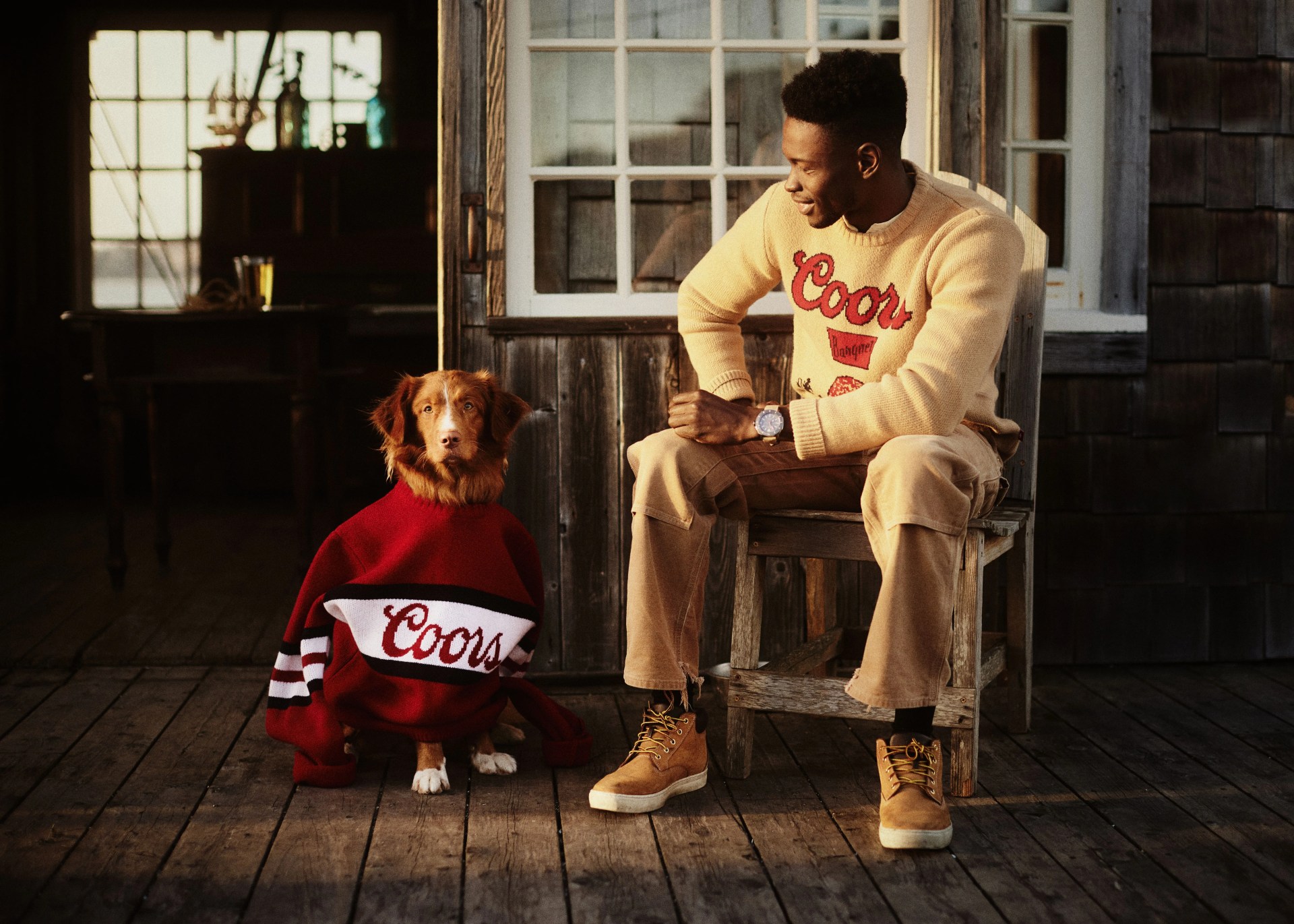 huckberry man wearing coors sweater sitting next to dog wearing a coors sweater