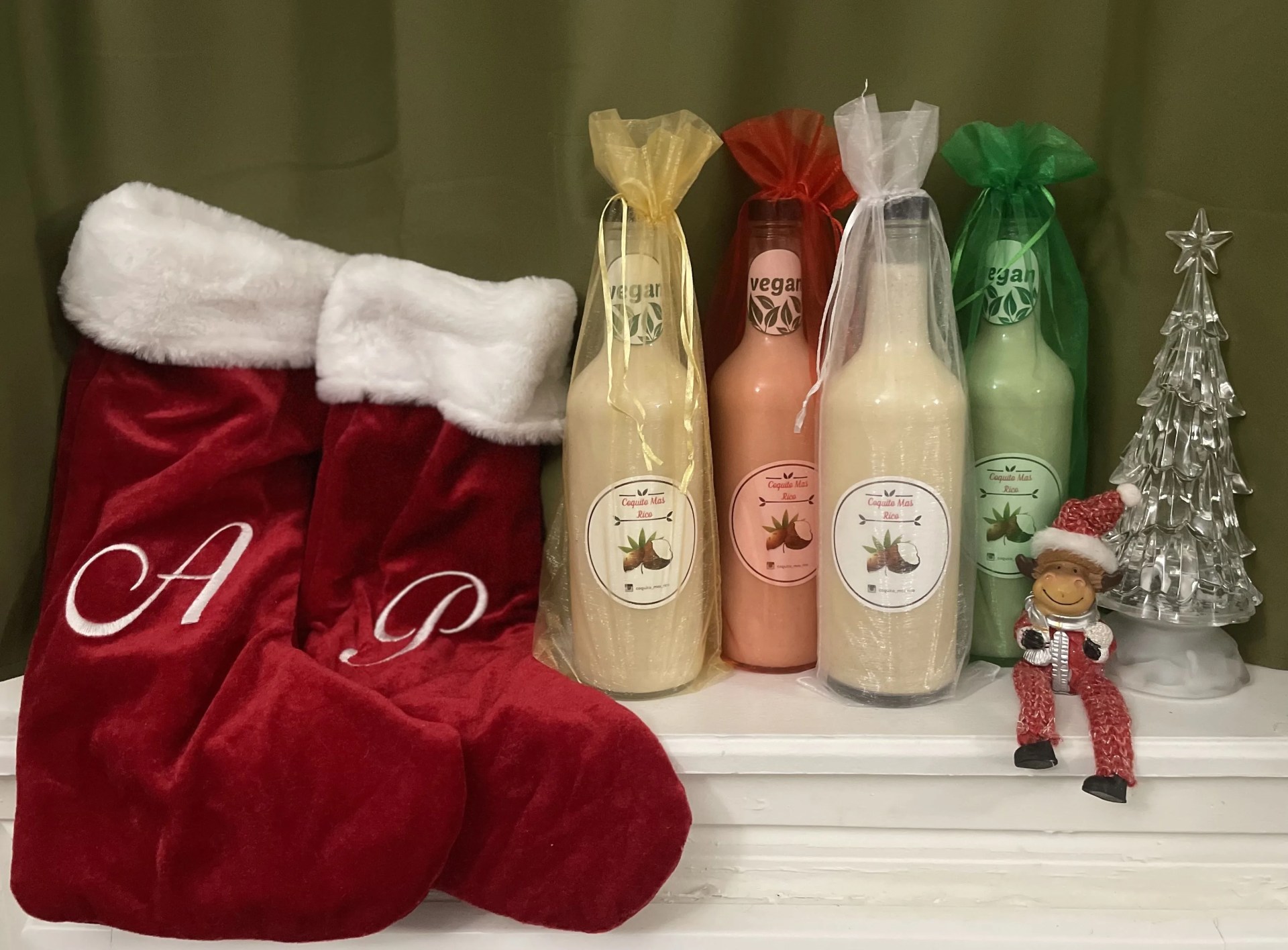 bottles of coquito on a christmas shelf with stockings