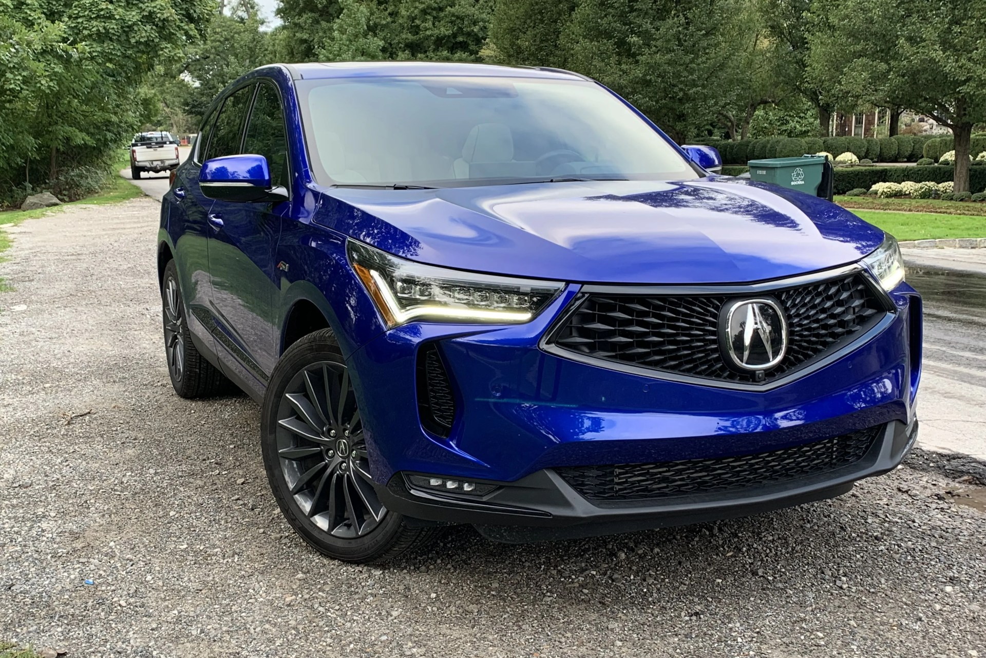 acura rdx parked on the side of a tree lined street