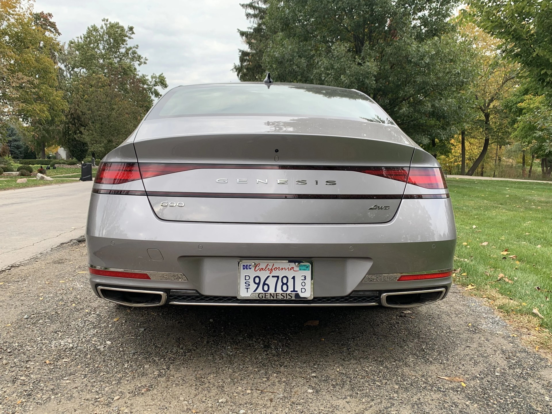 genesis g90 parked next to a park
