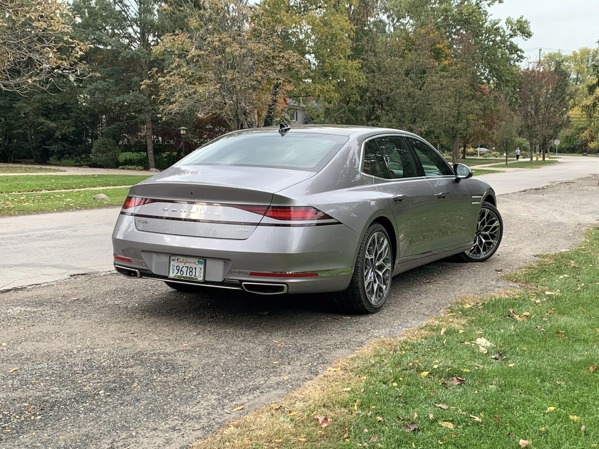 genesis g90 parked next to a park