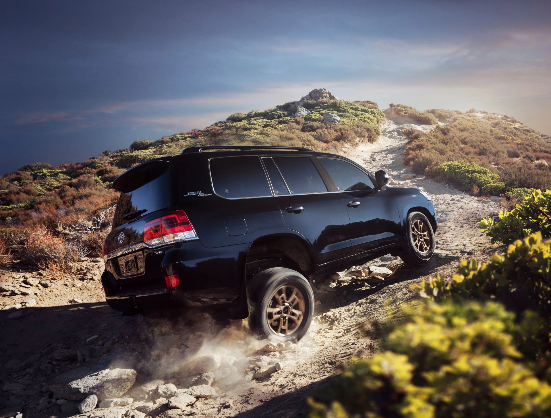 toyota land cruiser driving on a desert trail