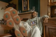 man sitting with foot up showing off new balance shoes and apparel