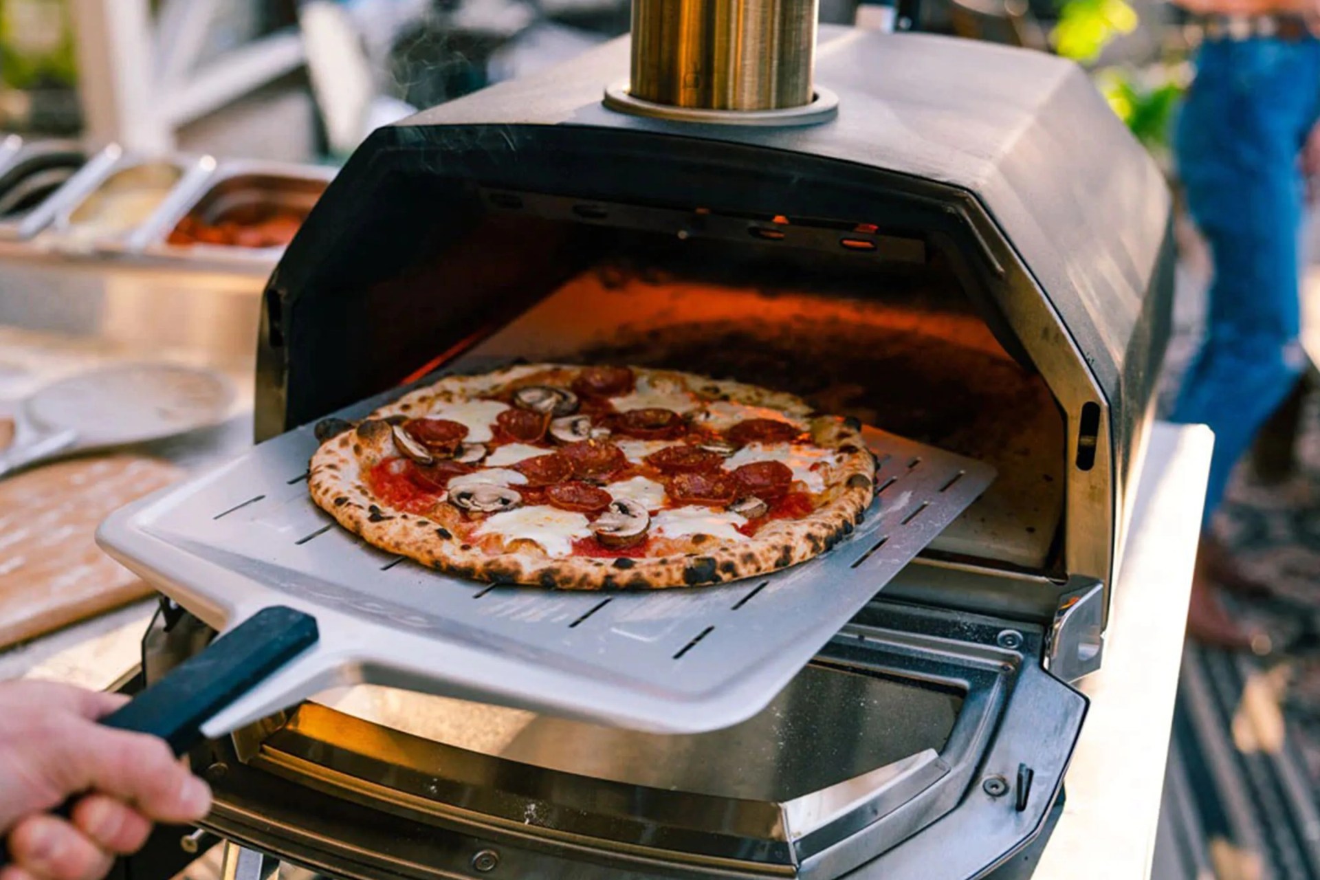 a cooked pizza coming out of a pizza oven