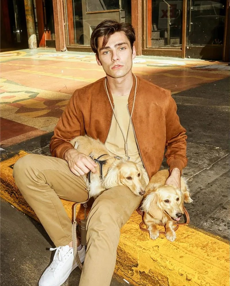 man sitting with his two dogs using the house of pagerie dog accessories