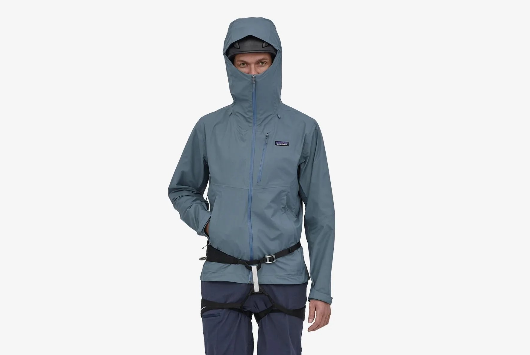 man wearing a patagonia rain jacket and harness