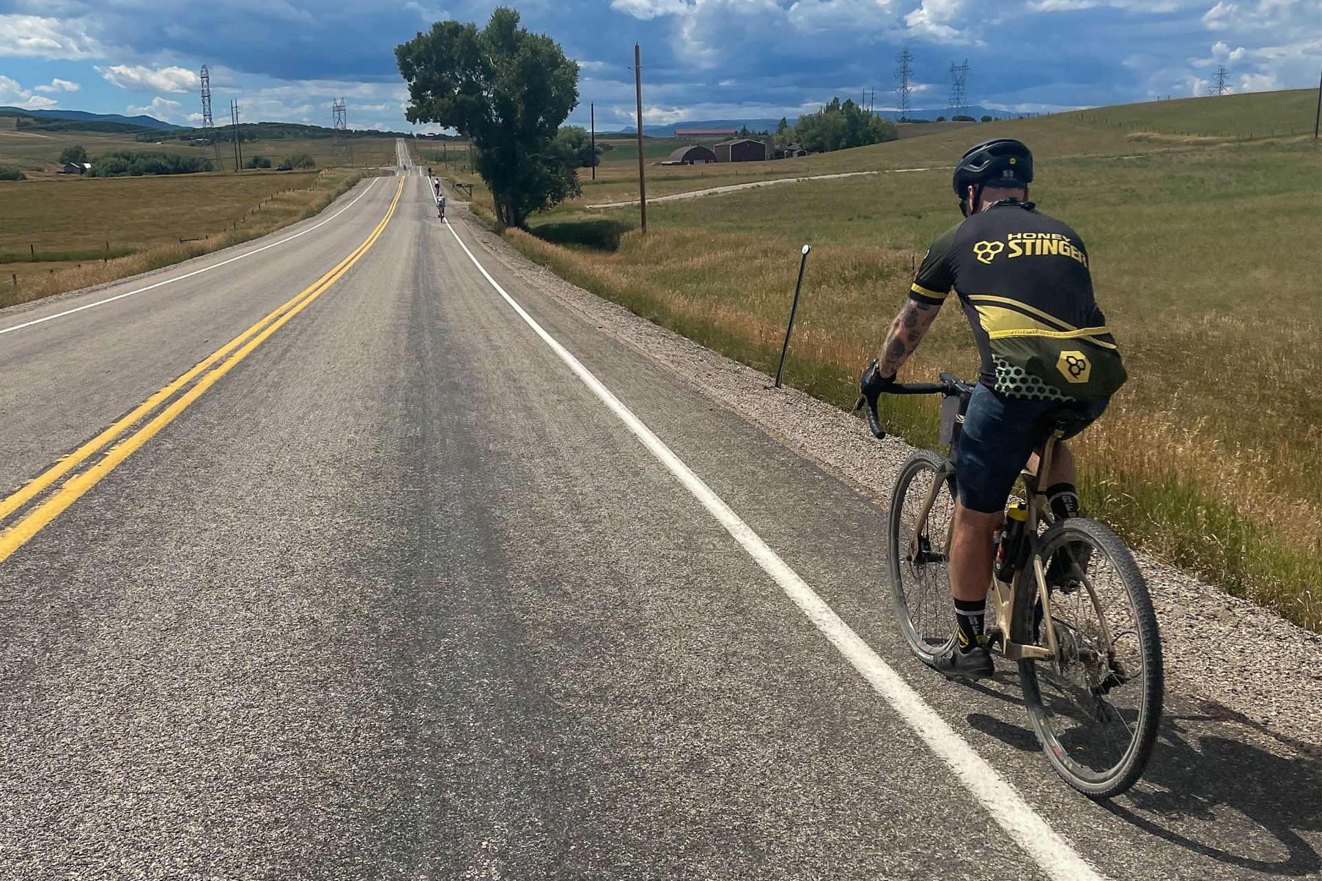 man riding a pinarello grevil f ekar gravel bike on a paved road