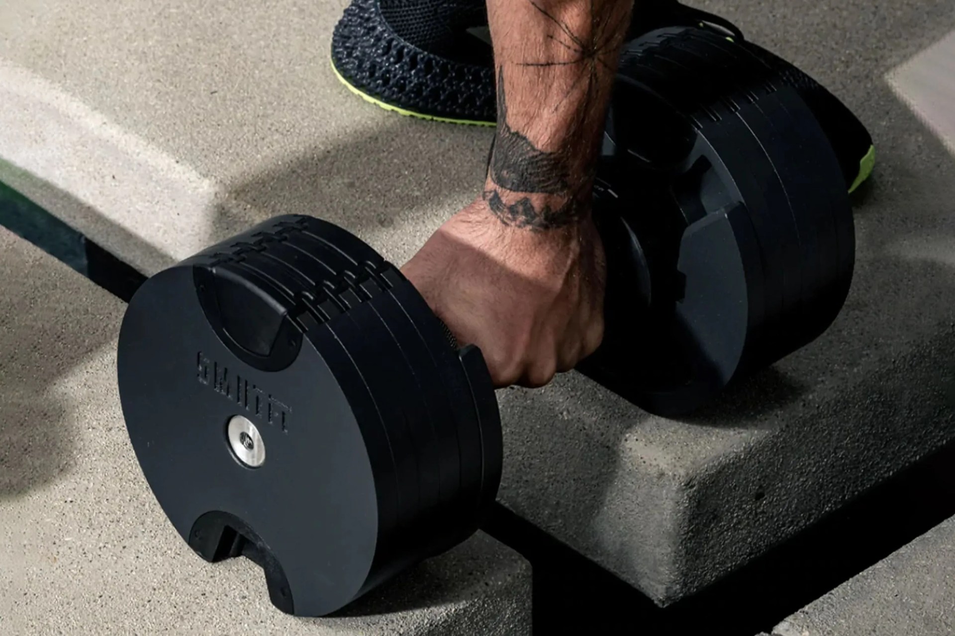 man picking up a smrtft dumbbell