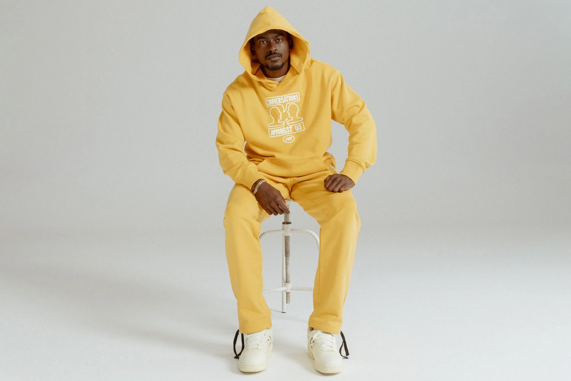 man wearing yellow conversations amongst us and new balance apparel and shoes