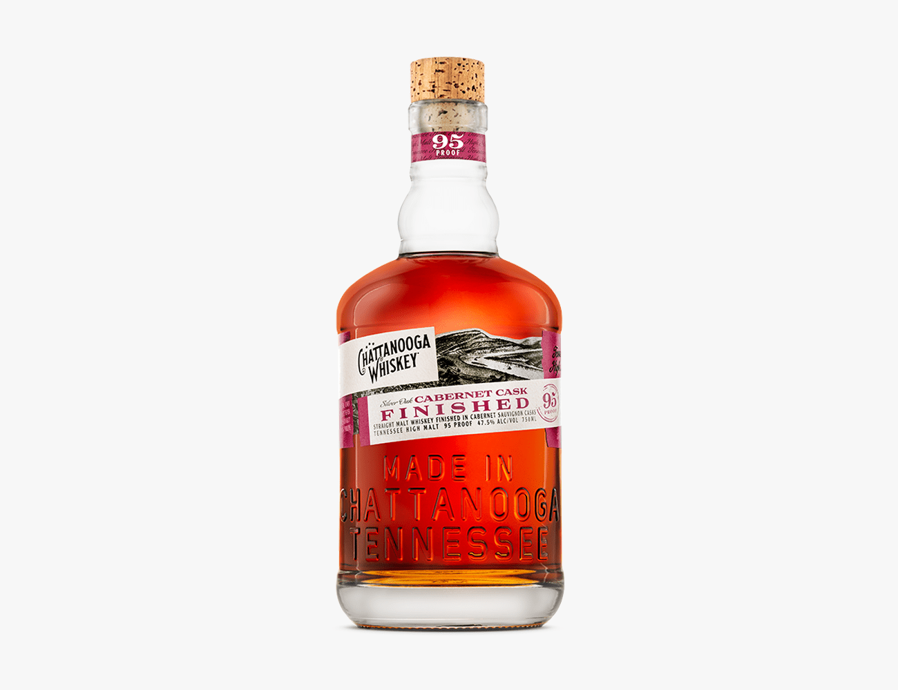 a glass bottle with a reddish brown liquor in it and a white and black label