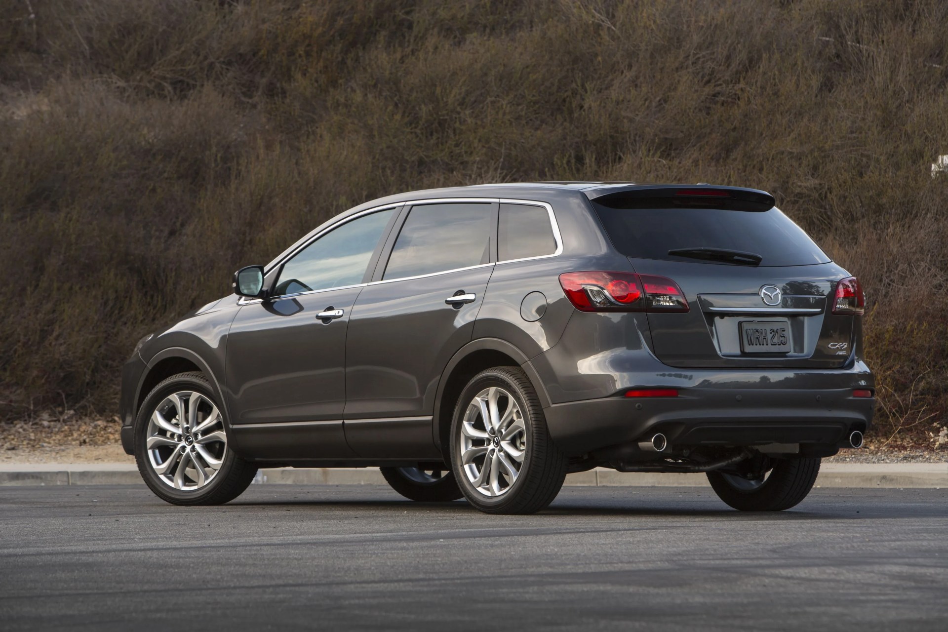 mazda cx 9 parked in front of woods