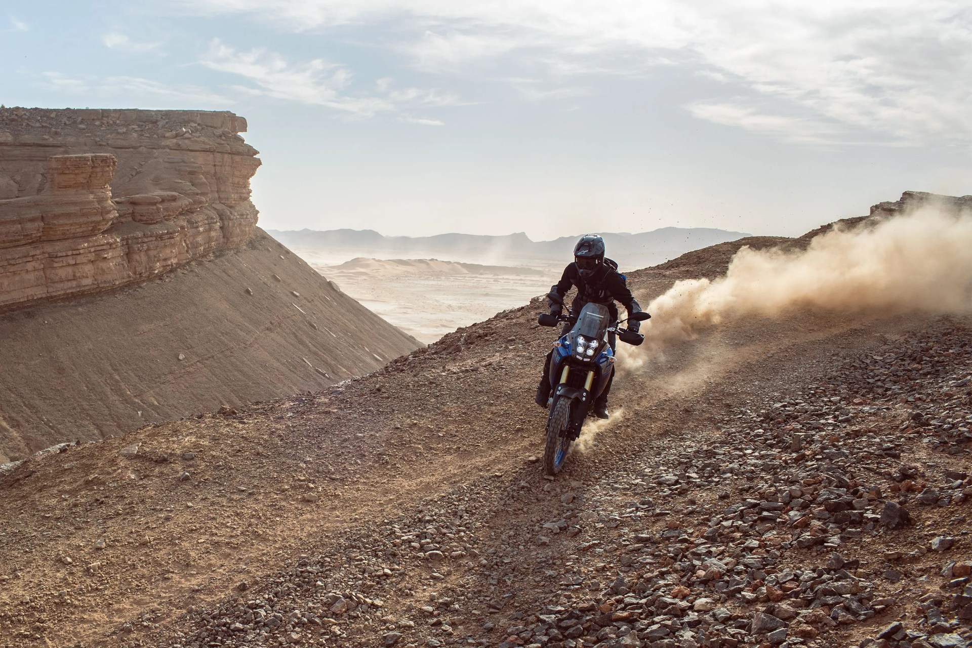 yamaha tenere 700 driving on dirt road through a canyon