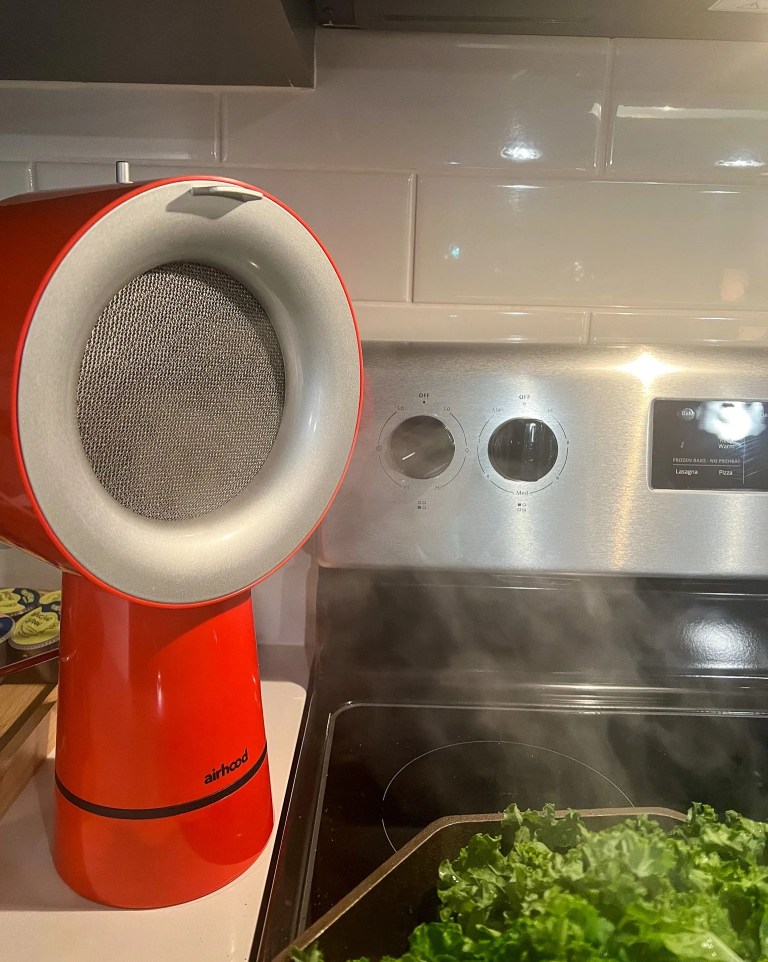 airhood vent next to a stove with a pan cooking