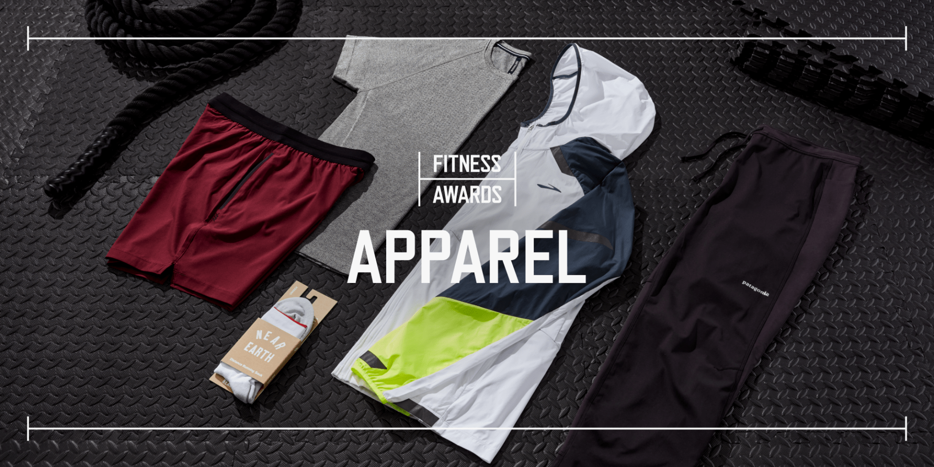 multiple pieces of fitness apparel laid out on black rubber gym flooring with text saying fitness awards apparel laid overtop the photo