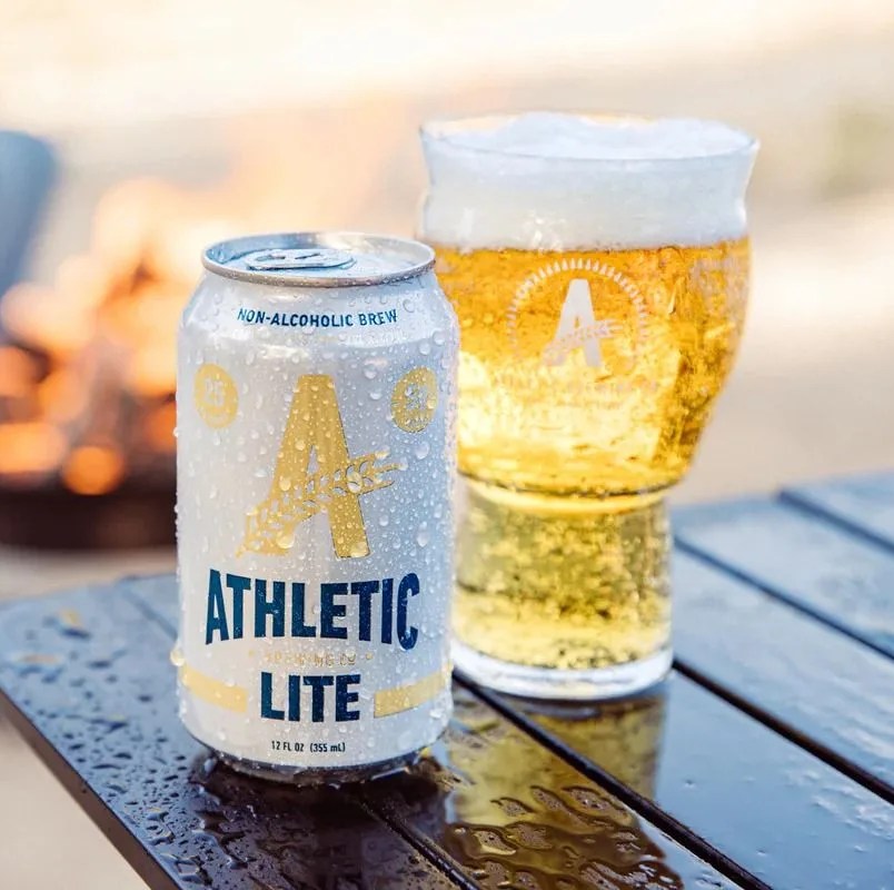 athletic brewing beer on a table by a fire