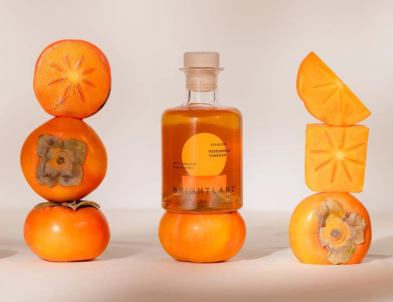 persimmon vinegar bottle next to fresh persimmons