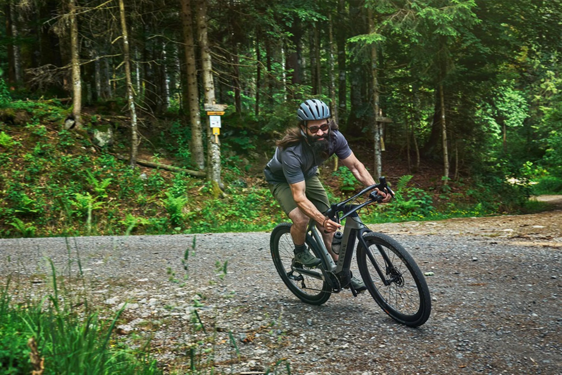 a man riding a bike on a gravel road