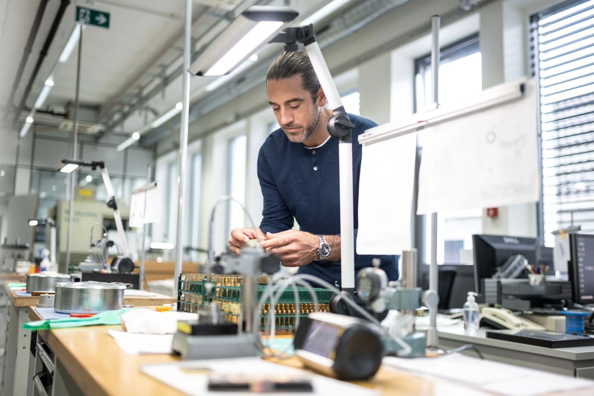 aaron rodgers at the zenith workshop looking at watch pieces
