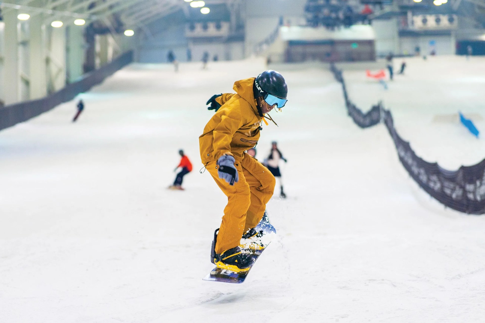 a kid snowboarding in an indoor snow sports space