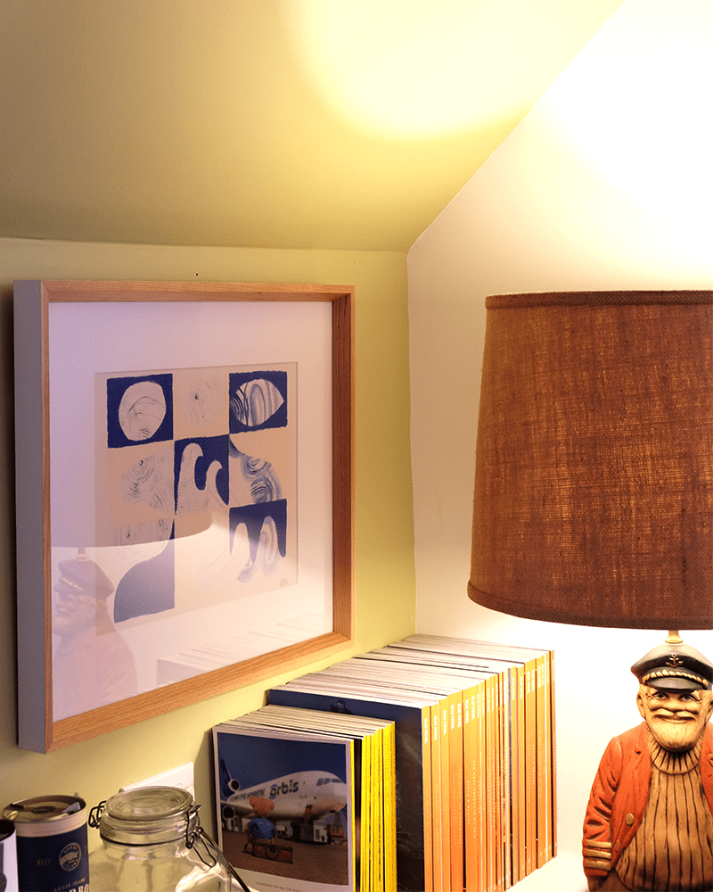a close up of ryans office showing a print, multiple magazines and a novelty sailor lamp