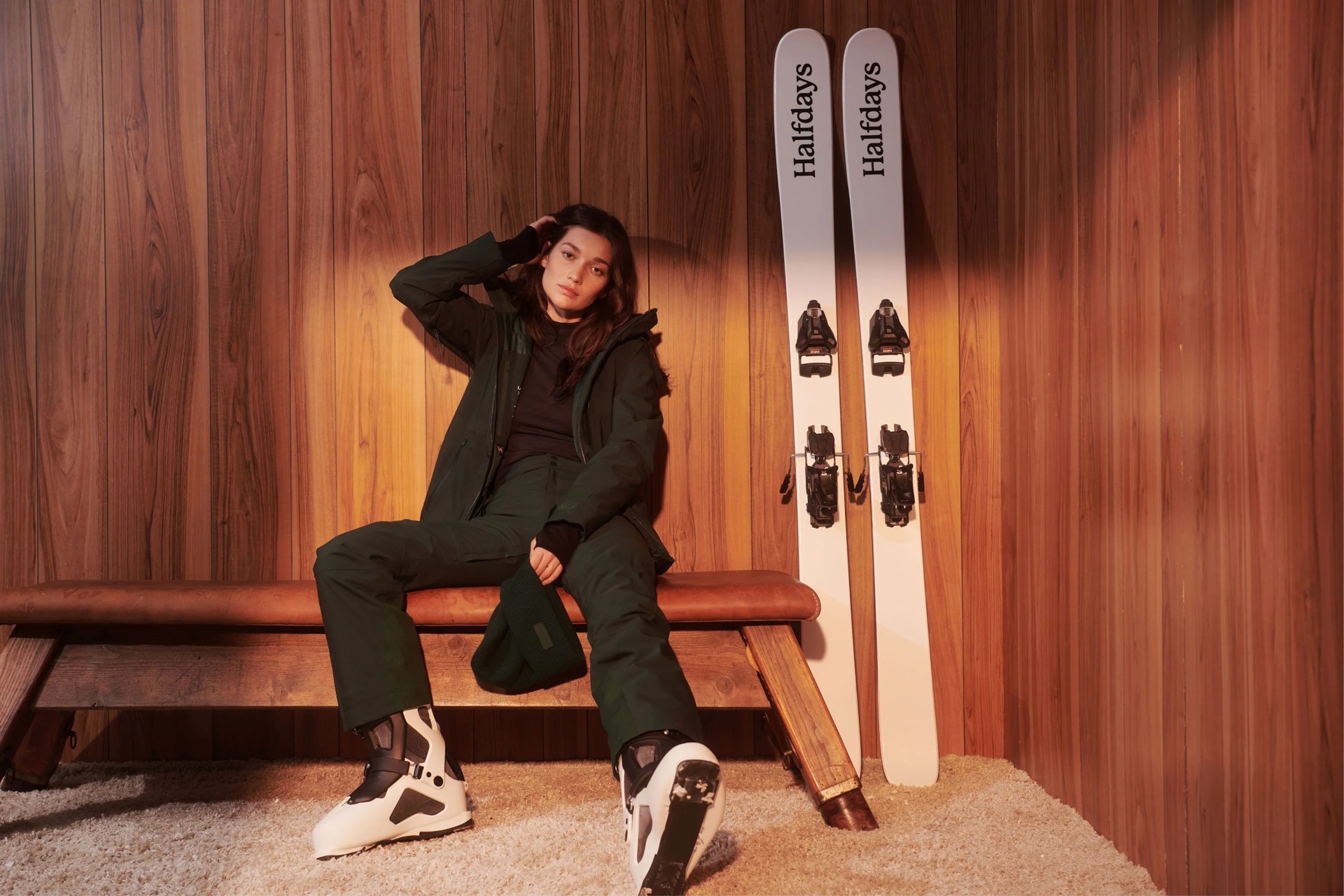 woman sitting down next to ski gear wearing halfdays alessandra pant