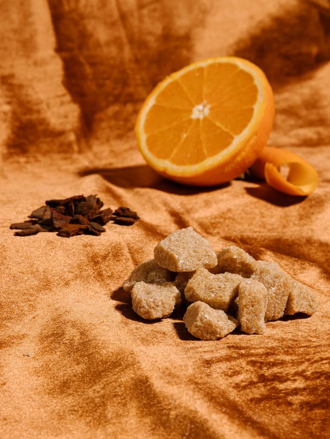 sugar cubes and oranges on a brown fabric