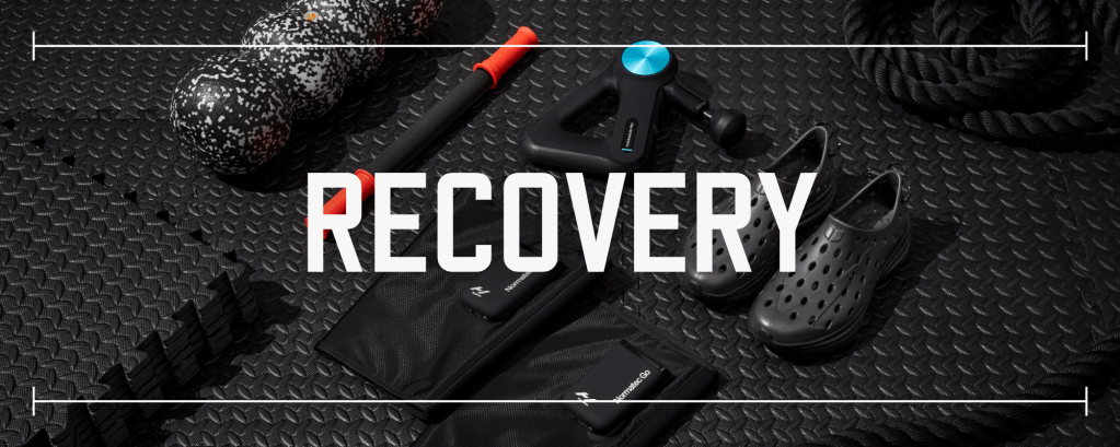 multiple pieces of fitness recovery gear in various colors laid out on black rubber gym flooring with text saying recovery laid over top the photo