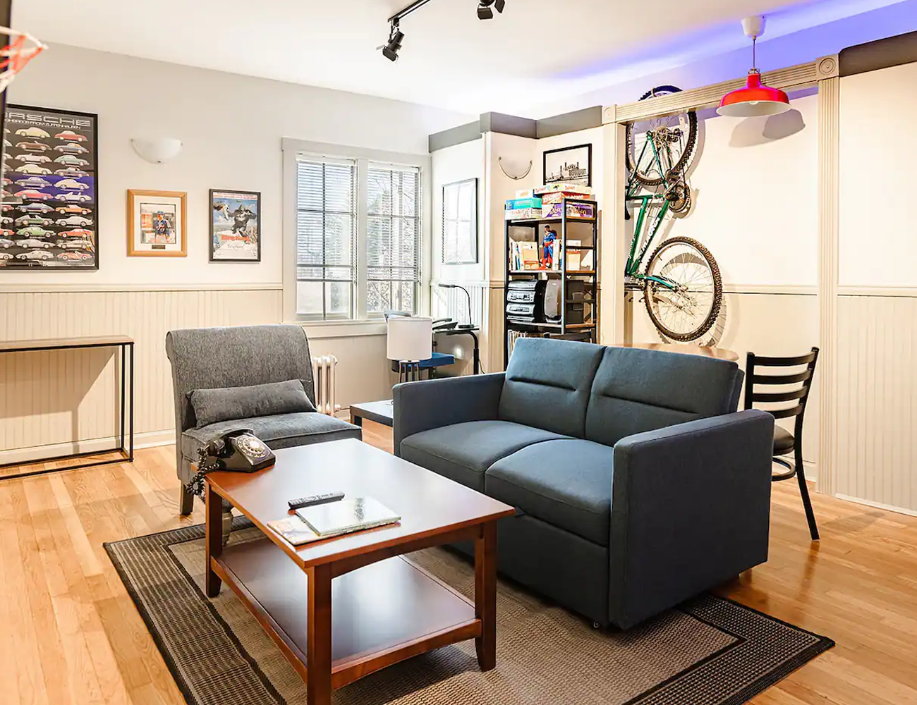 a living room setup with blue couch wood coffee table green chair and a green bike