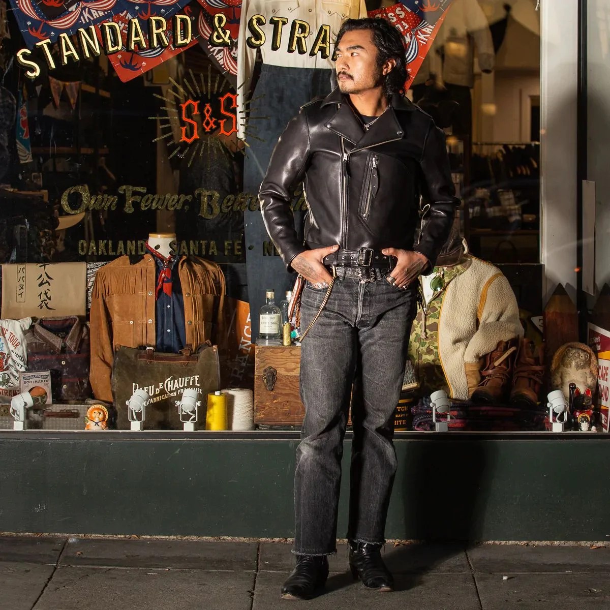 man wearing standard and strange jacket standing in front of store