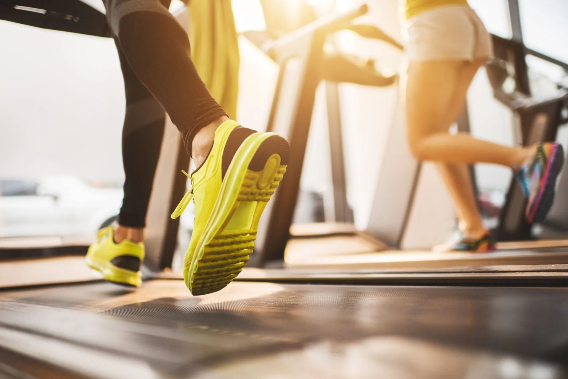 unrecognizable people running on treadmills in a gym
